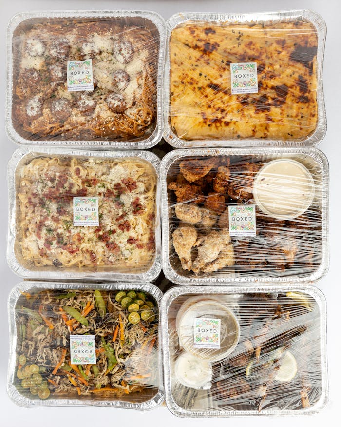 Top view of assorted Filipino meals in aluminum trays, perfect for delivery or catering services.
